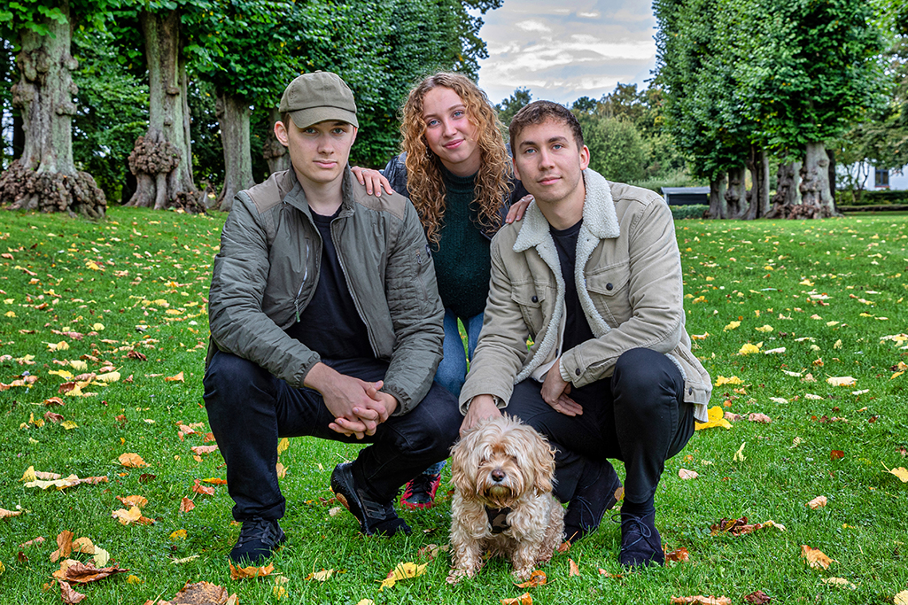 Tre søskende og deres hund i en park